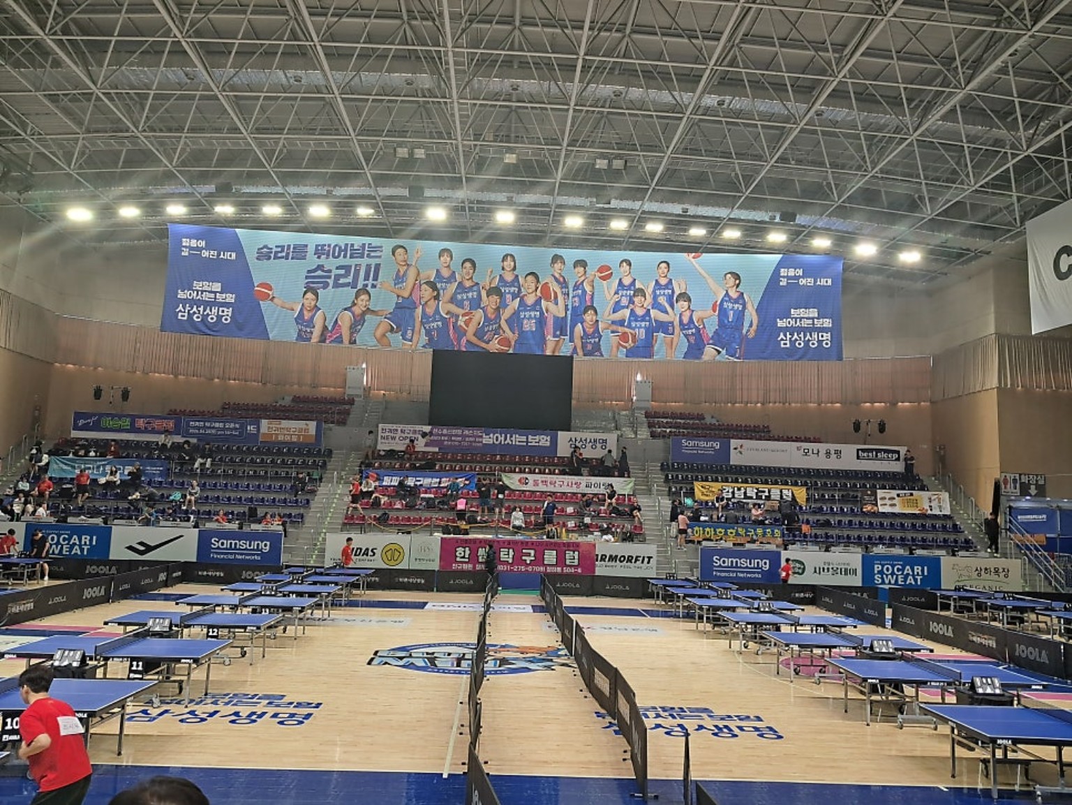 여러 탁구대와 관람석이 마련된 대회장 전경